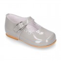 Classic patent leather little Mary Janes with perforated flower design.