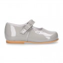 Classic patent leather little Mary Janes with perforated flower design.