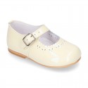 Classic patent leather little Mary Janes with perforated flower design.