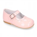 Classic patent leather little Mary Janes with perforated flower design.