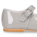 Classic patent leather little Mary Janes with perforated flower design.