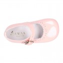 Classic patent leather little Mary Janes with perforated flower design.