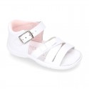 Washable leather sandal shoes with crossed strips and ribbon for little girls.