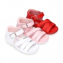 Washable leather sandal shoes with crossed strips and ribbon for little girls.