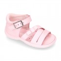 Washable leather sandal shoes with crossed strips and ribbon for little girls.