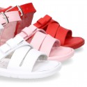 Washable leather sandal shoes with crossed strips and ribbon for little girls.