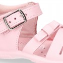 Washable leather sandal shoes with crossed strips and ribbon for little girls.