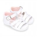 Washable leather sandal shoes with crossed strips and ribbon for little girls.