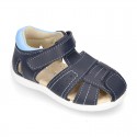 Washable leather kids sandal shoes with crossed straps and hook and loop strap closure.