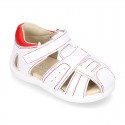 Washable leather kids sandal shoes with crossed straps and hook and loop strap closure.