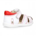 Washable leather kids sandal shoes with crossed straps and hook and loop strap closure.