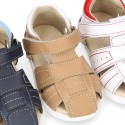 Washable leather kids sandal shoes with crossed straps and hook and loop strap closure.