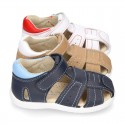 Washable leather kids sandal shoes with crossed straps and hook and loop strap closure.