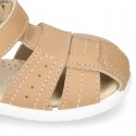 Washable leather kids sandal shoes with crossed straps and hook and loop strap closure.