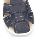 Washable leather kids sandal shoes with crossed straps and hook and loop strap closure.