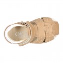 Washable leather kids sandal shoes with crossed straps and hook and loop strap closure.