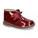 Classic Safari Boots with laces closure and waves in patent leather.