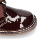 Classic Safari Boots with laces closure and waves in patent leather.