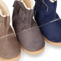 Autumn winter canvas ankle boots with hook and loop strap and fake hair lining.