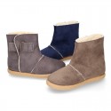 Autumn winter canvas ankle boots with hook and loop strap and fake hair lining.