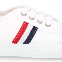 Cotton canvas kids tennis shoes to dress with shoelaces and flag design.