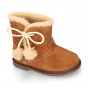 Little ankle boot shoes with FAKE HAIR lining and POMPOMS design in suede leather for first steps.