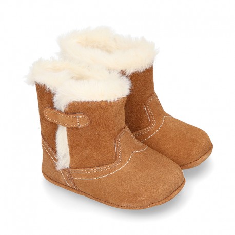 Baby bootie with hook and loop strap closure in suede leather.