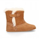 Baby bootie with hook and loop strap closure in suede leather.