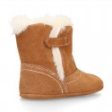 Baby bootie with hook and loop strap closure in suede leather.