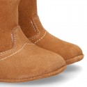 Baby bootie with hook and loop strap closure in suede leather.