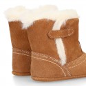 Baby bootie with hook and loop strap closure in suede leather.