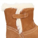 Baby bootie with hook and loop strap closure in suede leather.