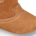 Baby bootie with hook and loop strap closure in suede leather.