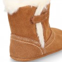 Baby bootie with hook and loop strap closure in suede leather.