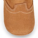 Baby bootie with hook and loop strap closure in suede leather.