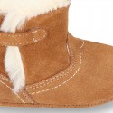 Baby bootie with hook and loop strap closure in suede leather.