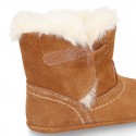 Baby bootie with hook and loop strap closure in suede leather.
