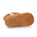 Baby bootie with hook and loop strap closure in suede leather.