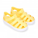 SNEAKER style kids jelly shoes with hook and loop strap in solid colors.