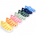 SNEAKER style kids jelly shoes with hook and loop strap in solid colors.