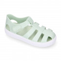 SNEAKER style kids jelly shoes with hook and loop strap in solid colors.