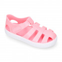 SNEAKER style kids jelly shoes with hook and loop strap in solid colors.