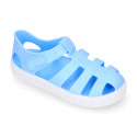 SNEAKER style kids jelly shoes with hook and loop strap in solid colors.