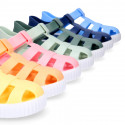 SNEAKER style kids jelly shoes with hook and loop strap in solid colors.