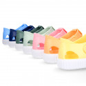 SNEAKER style kids jelly shoes with hook and loop strap in solid colors.