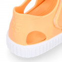 SNEAKER style kids jelly shoes with hook and loop strap in solid colors.