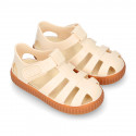 SNEAKER style kids jelly shoes with hook and loop strap in solid colors and caramel soles.