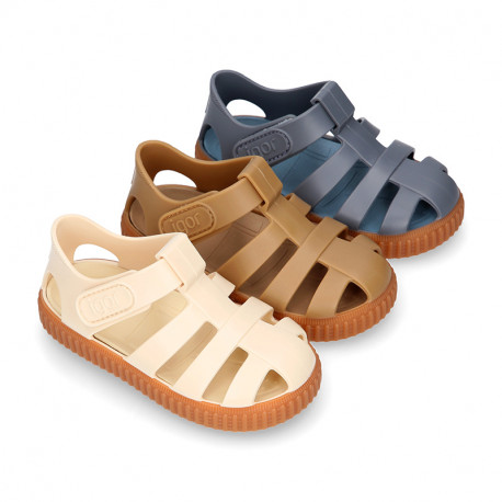 SNEAKER style kids jelly shoes with hook and loop strap in solid colors and caramel soles.