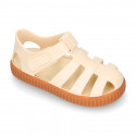 SNEAKER style kids jelly shoes with hook and loop strap in solid colors and caramel soles.