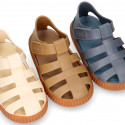 SNEAKER style kids jelly shoes with hook and loop strap in solid colors and caramel soles.